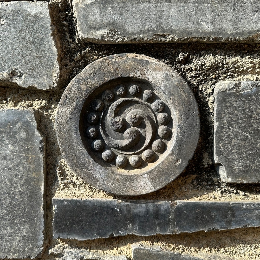 A stone with a sacred symbol carved in it, representing mindfulness mentoring with Robert Lurye.
